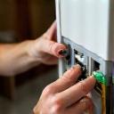 Technician installing internet modem at rural property